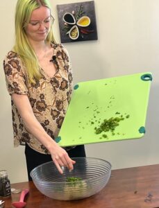 Jessica adding parsley to Herbed Parsley Salad recipe.