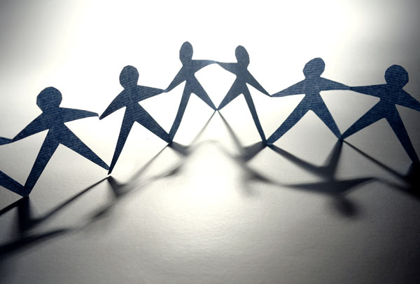 Paper cut outs of people holding hands