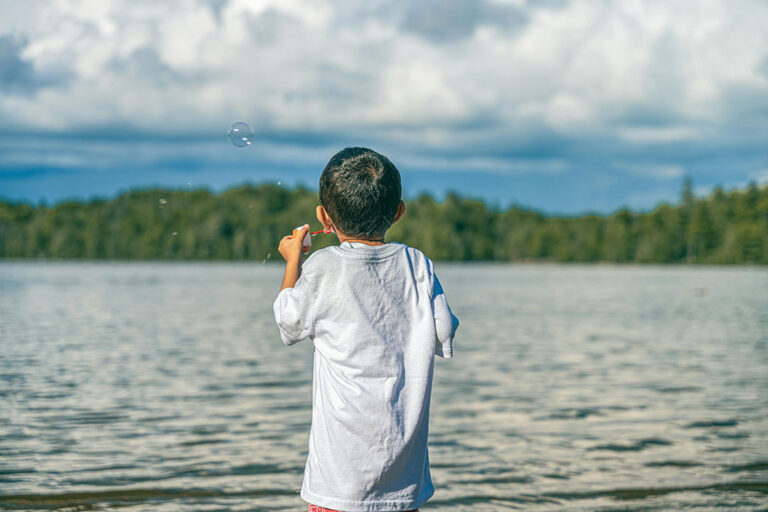 Troy blowing bubbles by a lake
